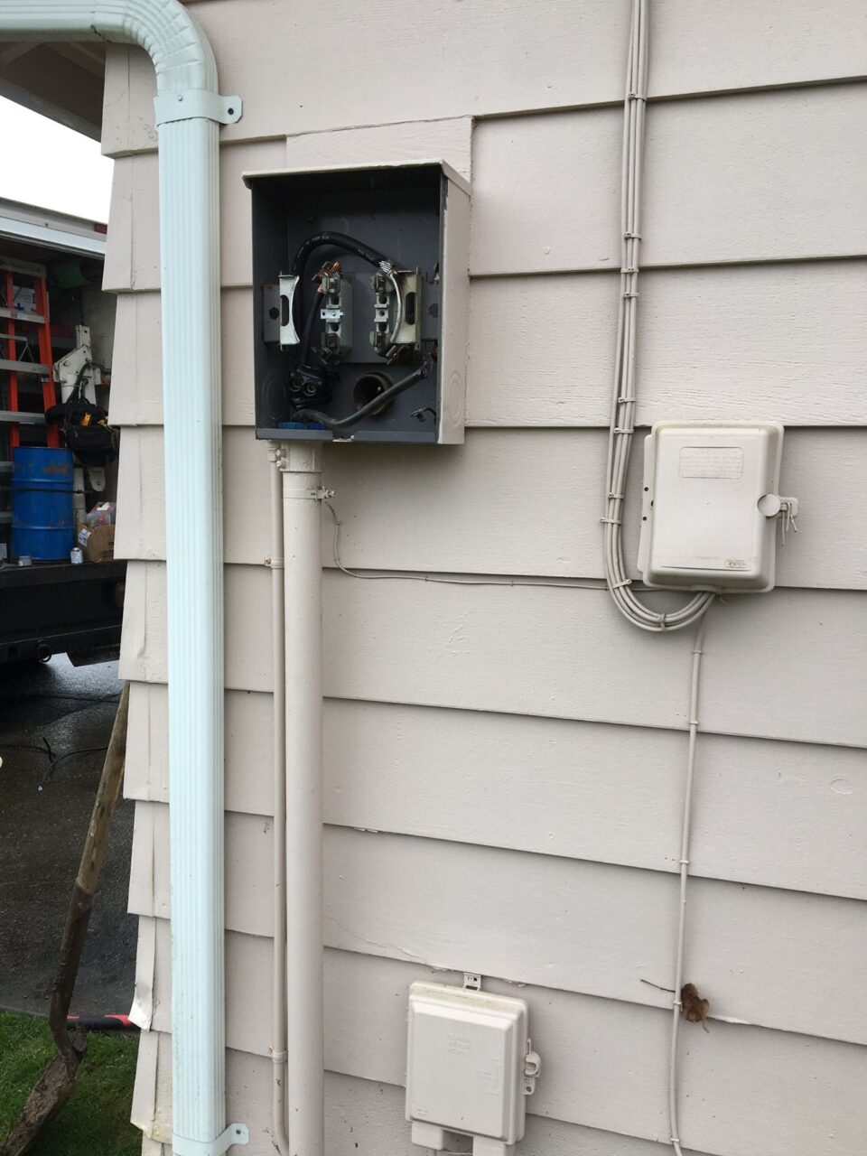 electric panel outside home eith panel cover missing